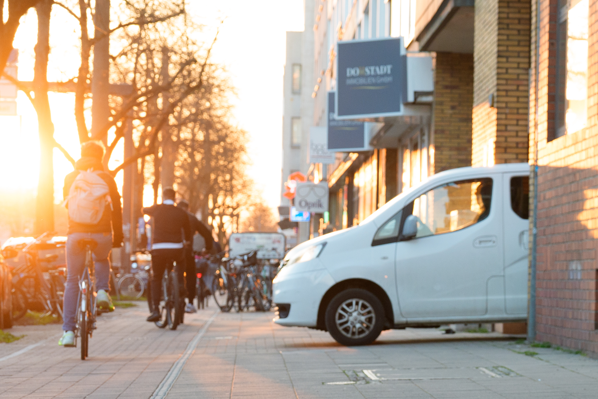 Straßenszene in Köln mit Lieferwagen und Radfahrern