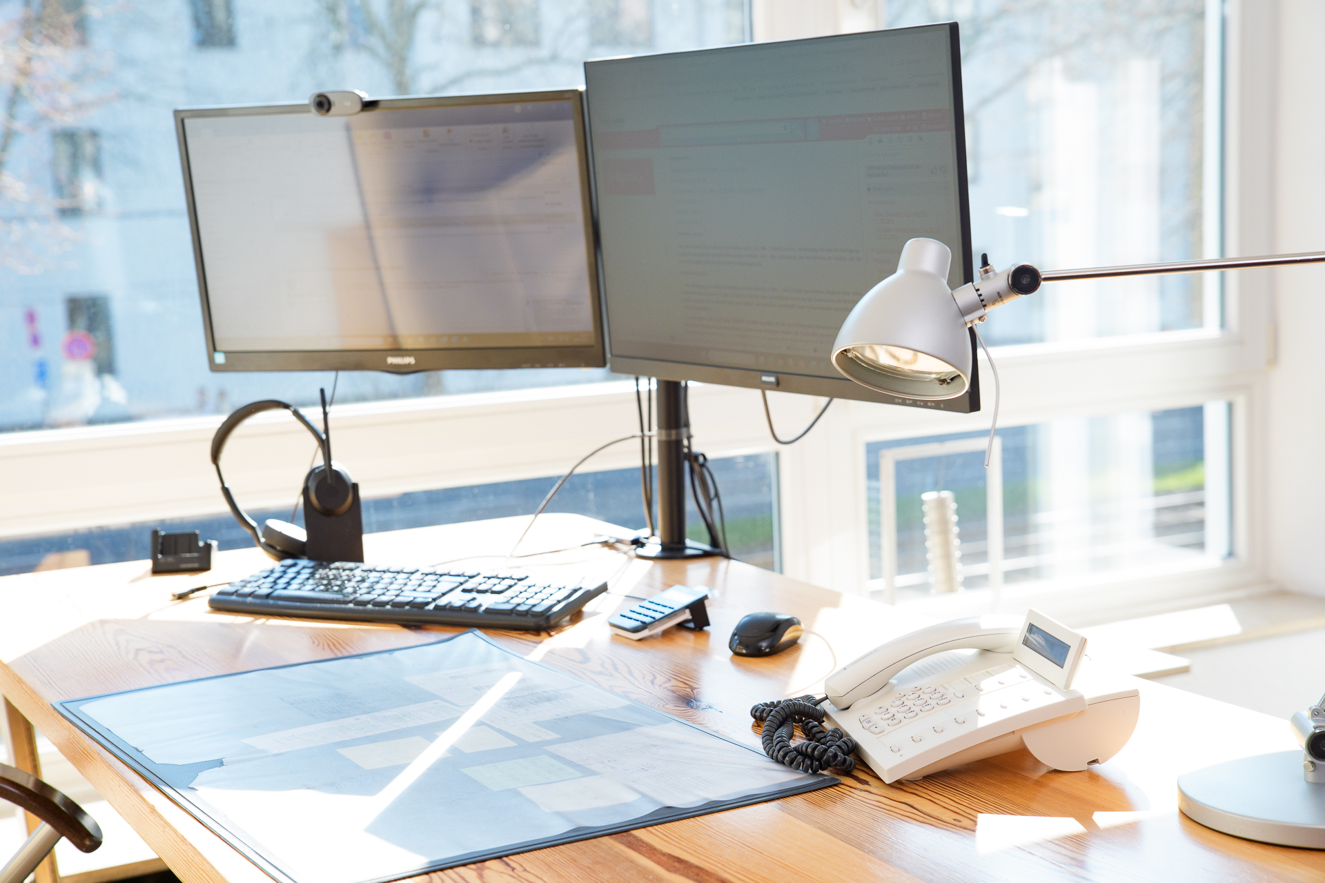 Arbeitsplatz mit zwei Monitoren, Telefon und Headset