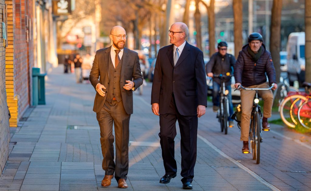 Henning Meier und Dr. Olaf Dörffer auf dem Gehweg, im Hintergrund Radfahrer