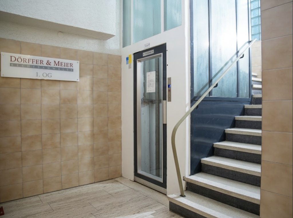 Eingangsbereich mit Aufzug, Treppe und Kanzleischild Dörffer & Meier